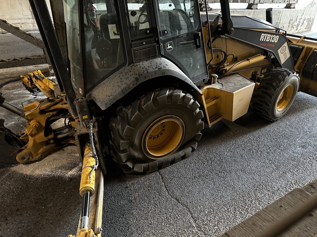 A truck and trailer hauling a backhoe hit and got stuck under a rail bridge at 1 Street and 9 Avenue SW, closing the road for several hours. (Nick Blakeney, CityNews image)