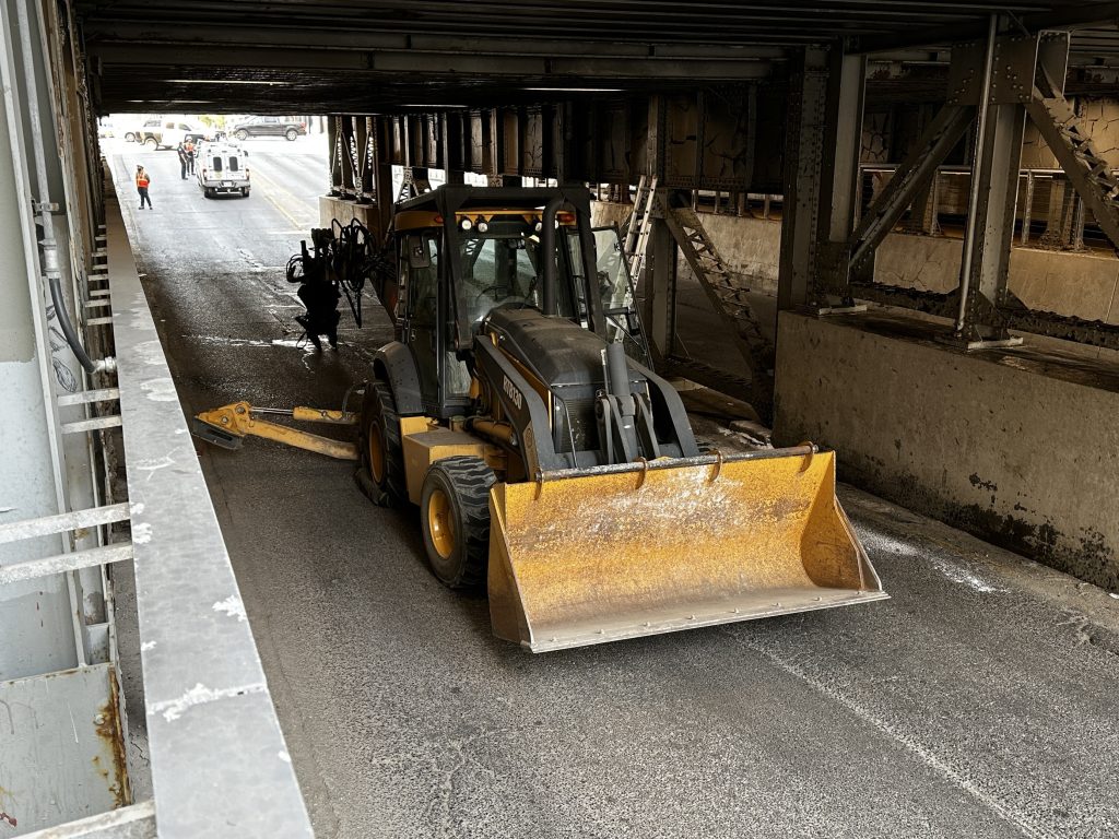 A truck and trailer hauling a backhoe hit and got stuck under a rail bridge at 1 Street and 9 Avenue SW, closing the road for several hours. (Nick Blakeney, CityNews image)