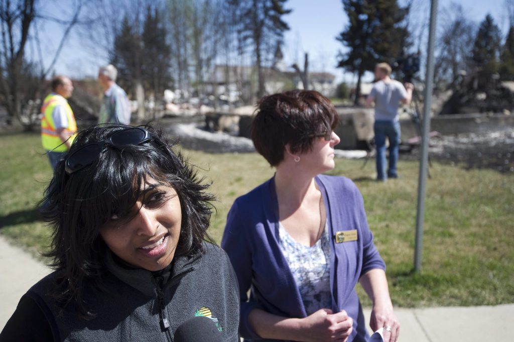 Karina Pillay, the mayor of Slave Lake, Alta., from 2004-2013, talks to the media in front of the remains of houses on Tuesday, May 17, 2011. THE CANADIAN PRESS/Ian Jackson