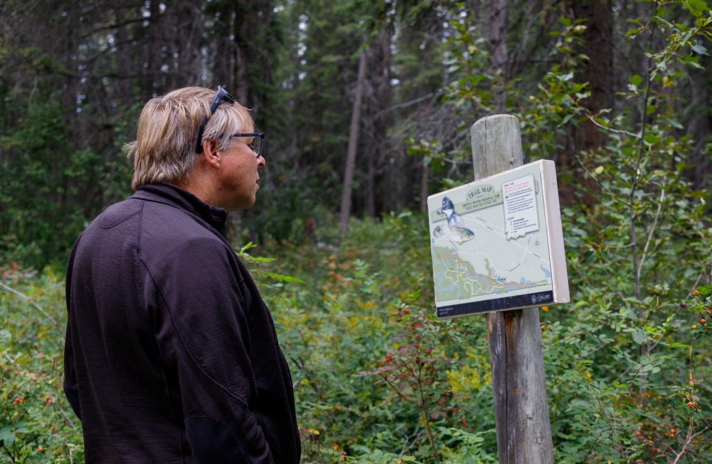 Ron Sparrow looks at a trail map for Griffith Woods in the Discovery Ridge neighbourhood in Calgary