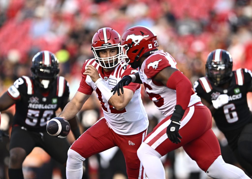 Calgary Stampeders quarterback Jake Maier (12) hands the ball to running back Dedrick Mills (26) during first half CFL football action against the Ottawa Redblacks in Ottawa on Friday, July 26, 2024