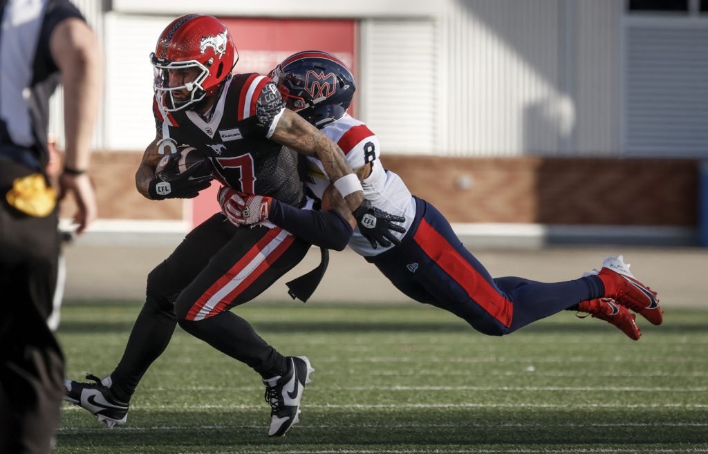 Montreal Alouettes' Nafees Lyon (8) tackles Calgary Stampeders' Cameron Echols-Luper (17) during first half CFL football action in Calgary