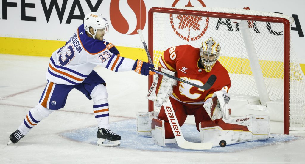 Edmonton Oilers' Viktor Arvidsson (33) swats at the puck in front of Calgary Flames' goalie Daniel Vladar (80) during first period NHL preseason hockey action in Calgary, Monday, Sept. 23, 2024.THE CANADIAN PRESS/Jeff McIntosh