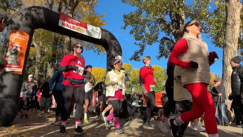 Calgarians pass through the starting gate for the 31st annual Alzheimer Walk and Run at Prince's Island Park in Calgary on Sunday, Oct. 13, 2024.