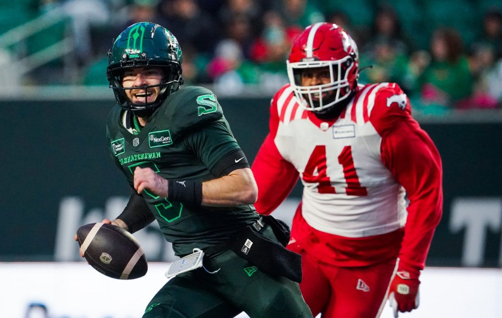 Saskatchewan Roughriders quarterback Shea Patterson (5) runs the football past Calgary Stampeders defensive lineman Mike Rose (41) during the first half of CFL football action in Regina, on Saturday, October 26, 2024.