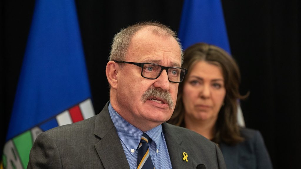 Minister of Municipal Affairs Ric McIver speaks as Alberta Premier Danielle Smith looks on during a press conference in Edmonton, April 10. THE CANADIAN PRESS/Jason Franson