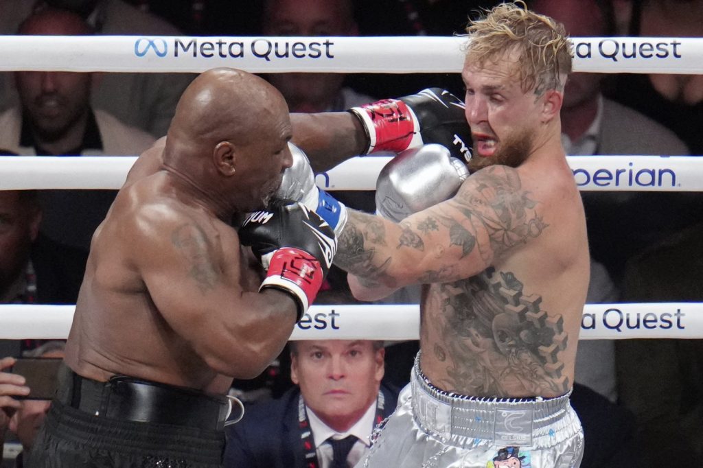 Mike Tyson hits Jake Paul during their heavyweight boxing match, Friday, Nov. 15, 2024