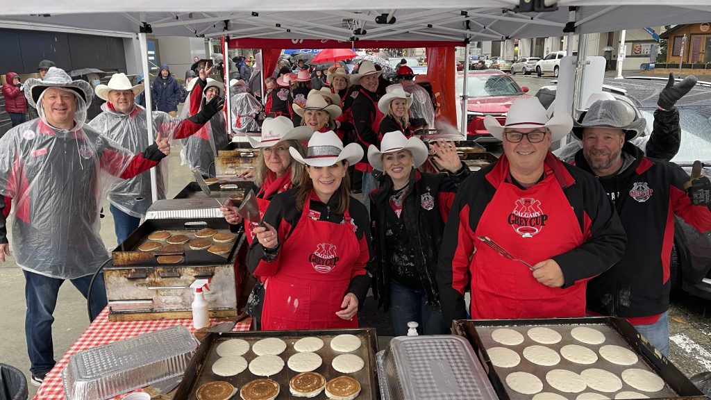 Members of the Calgary Grey Cup Committee pose for a photo while they serve pancakes. (Courtesy Calgary Grey Cup Committee)