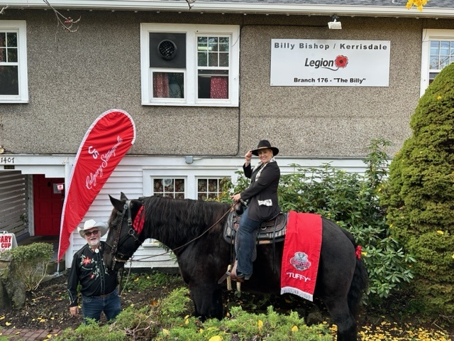 A member of the Calgary Grey Cup Committee poses for a photo with "Tuffy Nuff" the horse
