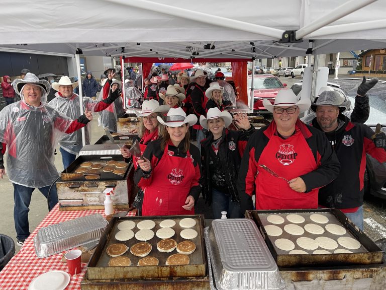 Members of the Calgary Grey Cup Committee pose for a photo while they serve pancakes. (Courtesy Calgary Grey Cup Committee)