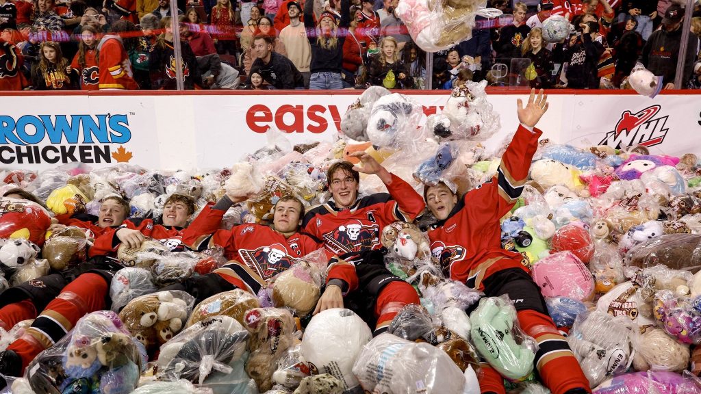 Calgary Hitmen players on a mountain of stuffed animals at the 30th annual Teddy Bear Toss at the ScotiabanK Saddledome on Sunday, Dec. 8, 2025. (@WHLHitmen)