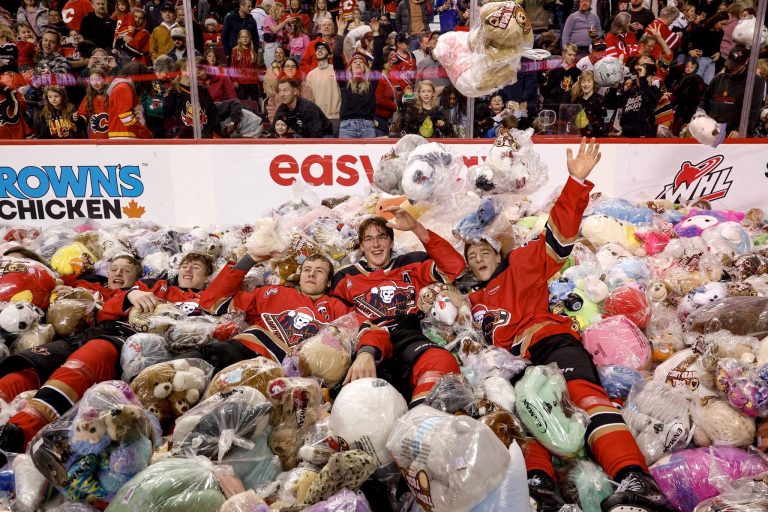 Calgary Hitmen players on a mountain of stuffed animals at the 30th annual Teddy Bear Toss at the ScotiabanK Saddledome on Sunday, Dec. 8, 2025. (@WHLHitmen)