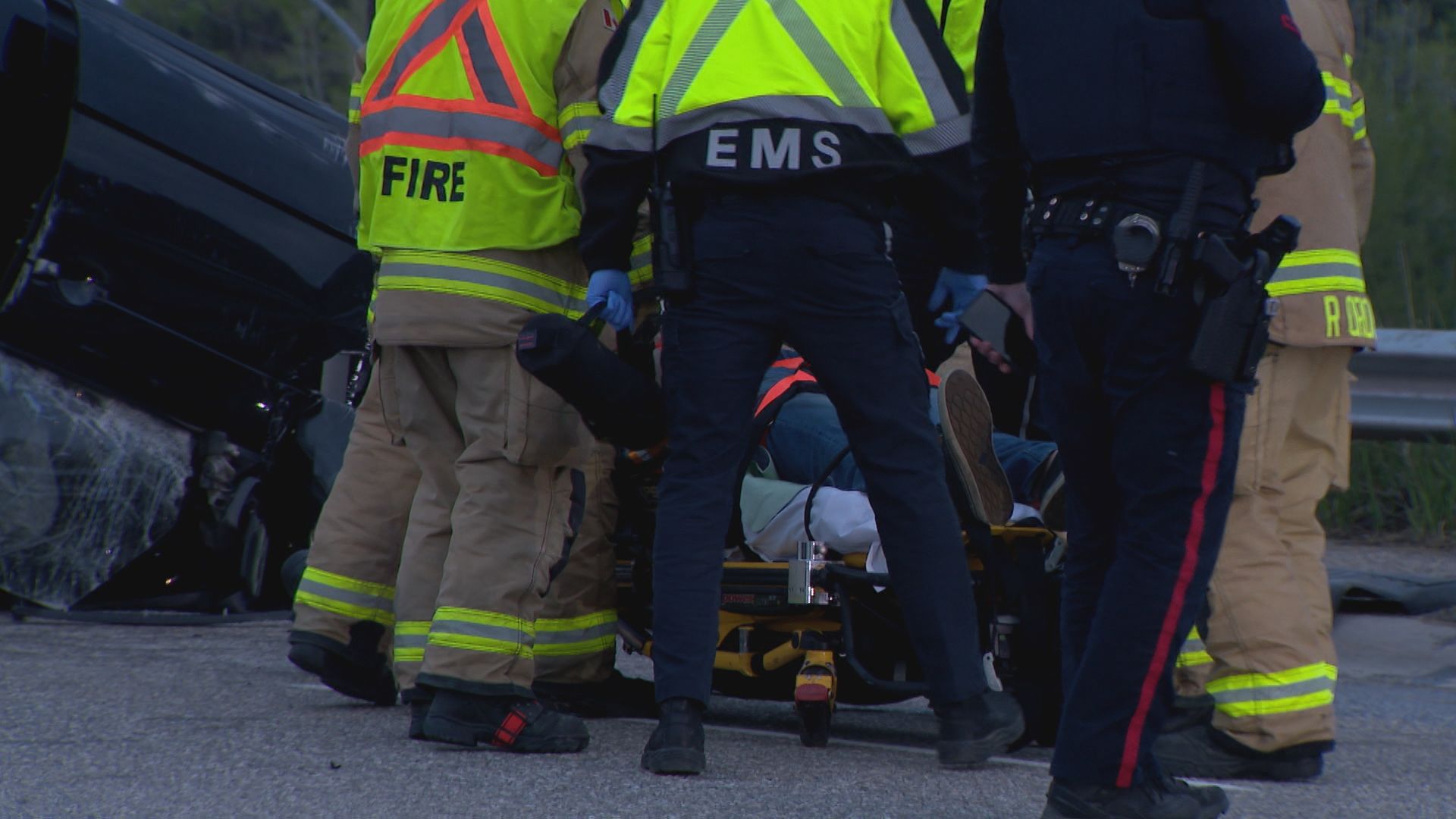 Emergency crews surround a person on a stretcher after a rollover happened on Memorial Drive in northwest Calgary on Saturday, May 16, 2026